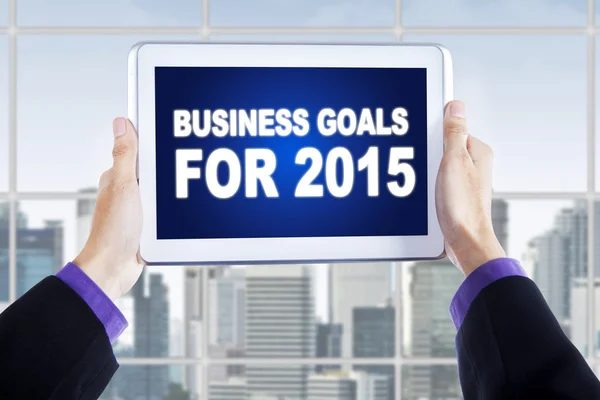 Mãos com tablet mostrando metas de negócios para 2015 — Fotografia de Stock