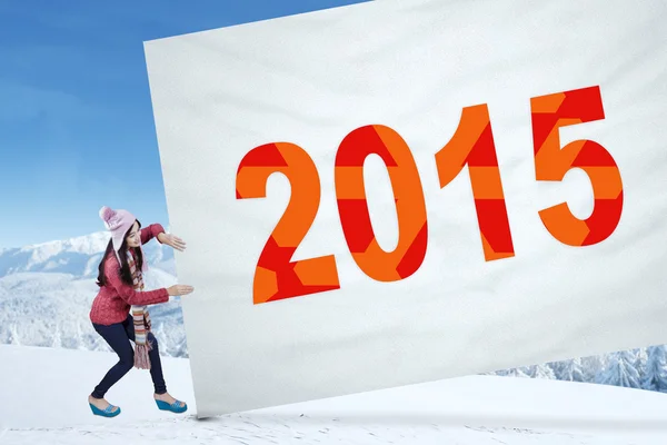 Girl pulling numbers 2015 on a banner — Stock Photo, Image