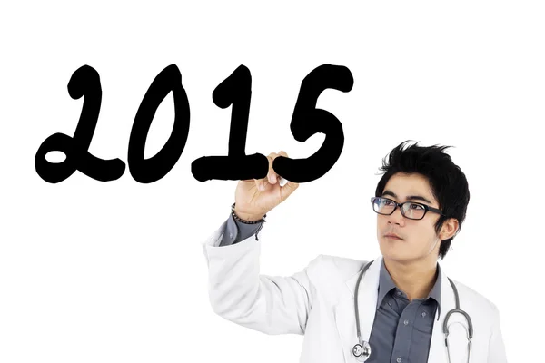 Manlig läkare skriver nummer 2015 på whiteboard — Stockfoto