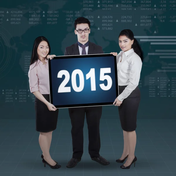 Mixed race entrepreneurs holding numbers 2015 — Stock Photo, Image