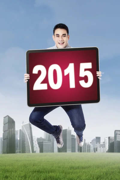Человек прыгает на поле с номером 2015 — стоковое фото