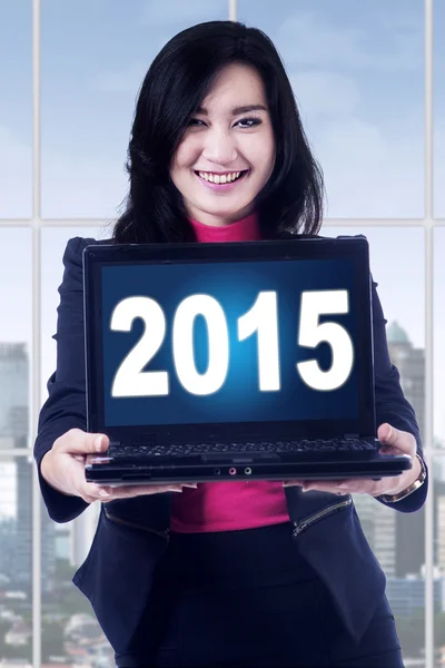 Pretty woman with numbers 2015 on laptop — Stock Photo, Image