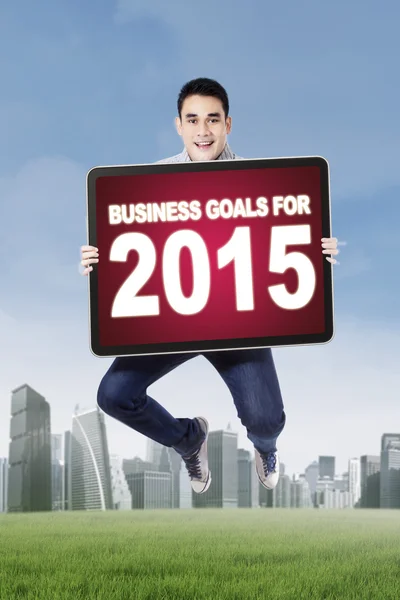 Young man jumping with business goals — Stock Photo, Image
