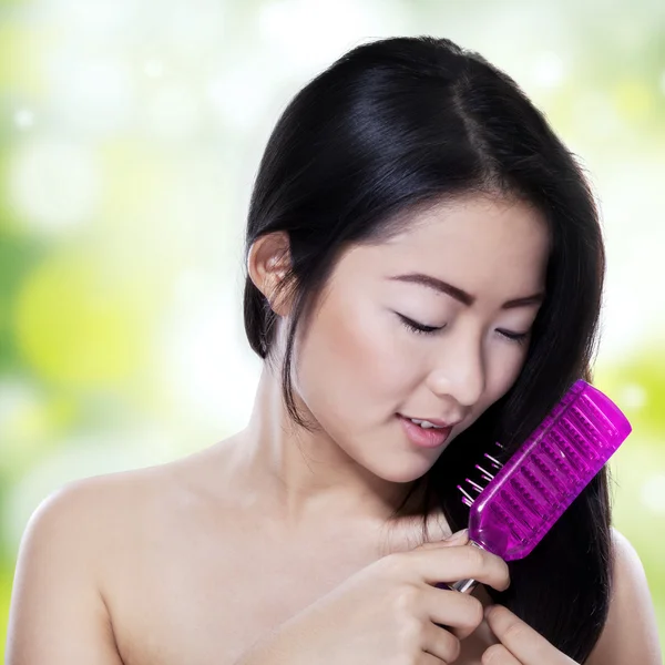 Beautiful girl combing her hair — Stock Photo, Image