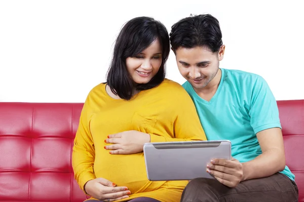 Zwangere vrouw met echtgenoot met behulp van Tablet PC — Stockfoto