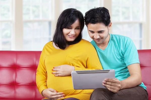 Nastávající žena se svým manželem pomocí tabletu — Stock fotografie