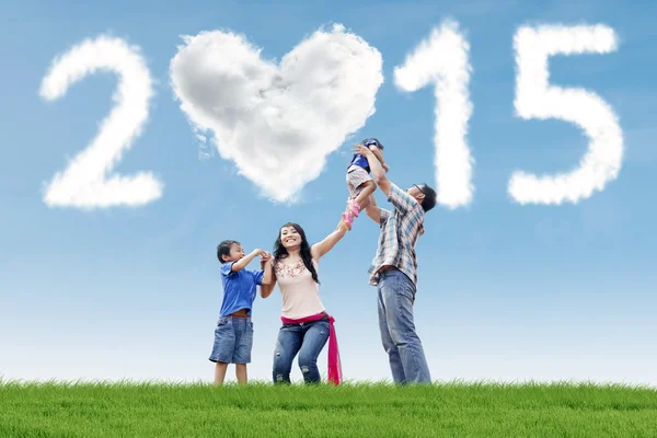 Familia bajo la nube de 2015 en el prado — Foto de Stock