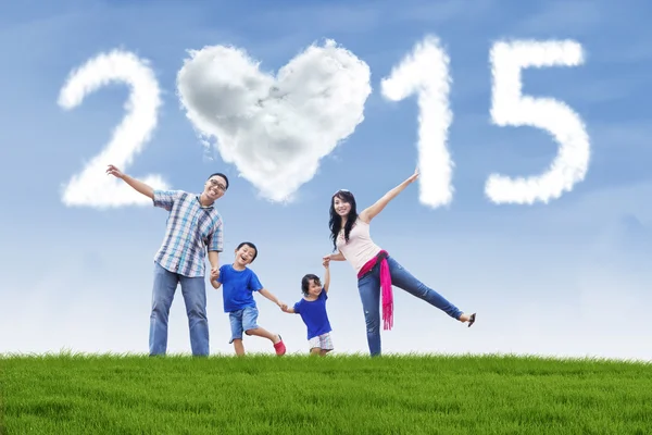 Famiglia si tiene per mano sul campo sotto la nuvola del 2015 — Foto Stock