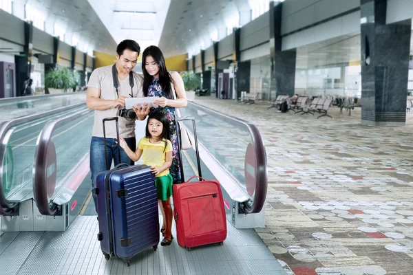 Glückliche Familie sucht eine Karte auf dem Tablet — Stockfoto