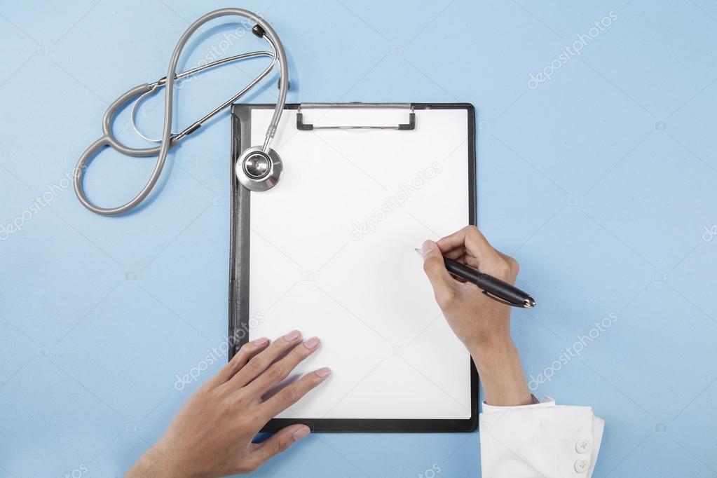 Doctor hands writing on clipboard