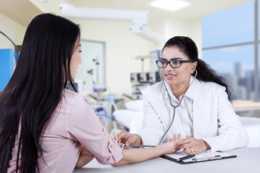 Asyalı doktor hasta kalp atışlarını dinleme