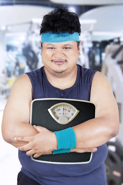 Ожиріння людини, що тримає шкалу у фітнес-центрі — стокове фото