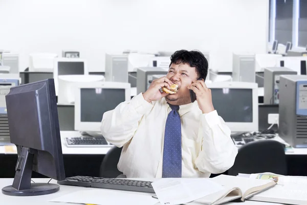 Obesidade gerente comer enquanto trabalha — Fotografia de Stock