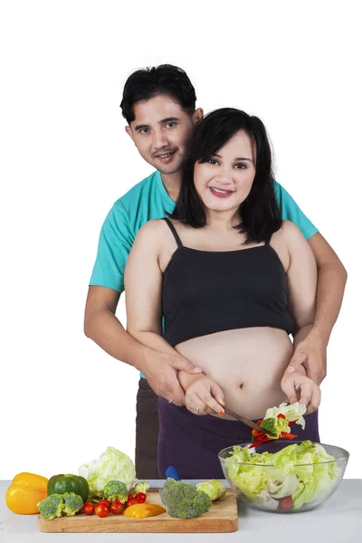 Mulher grávida com marido preparando salada — Fotografia de Stock