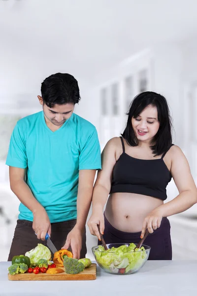 Mulher grávida na cozinha preparando salada — Fotografia de Stock