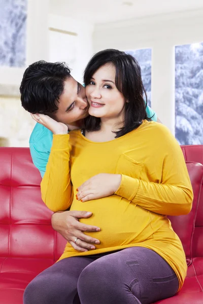 Jonge man zoenen zijn zwangere vrouw — Stockfoto
