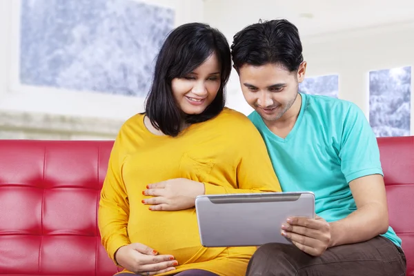 Jovem marido usando tablet com sua esposa — Fotografia de Stock