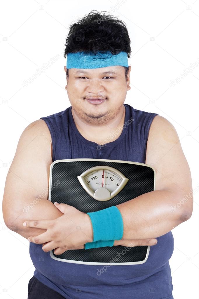 Overweight person holding weight scale