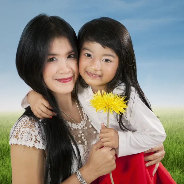 Ребенок держит цветок с родителями — стоковое фото