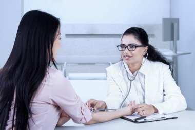 Kalp atışlarını dinlerken gülümseyen dost doktor