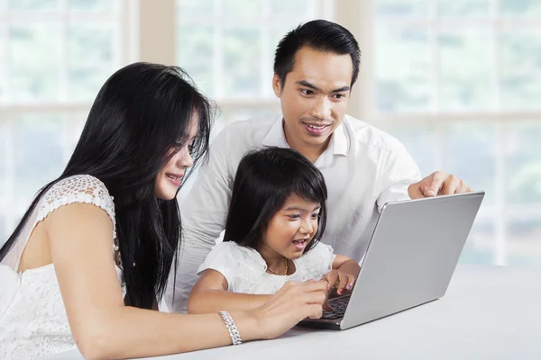 Familia feliz navegar por Internet con el ordenador portátil — Foto de Stock