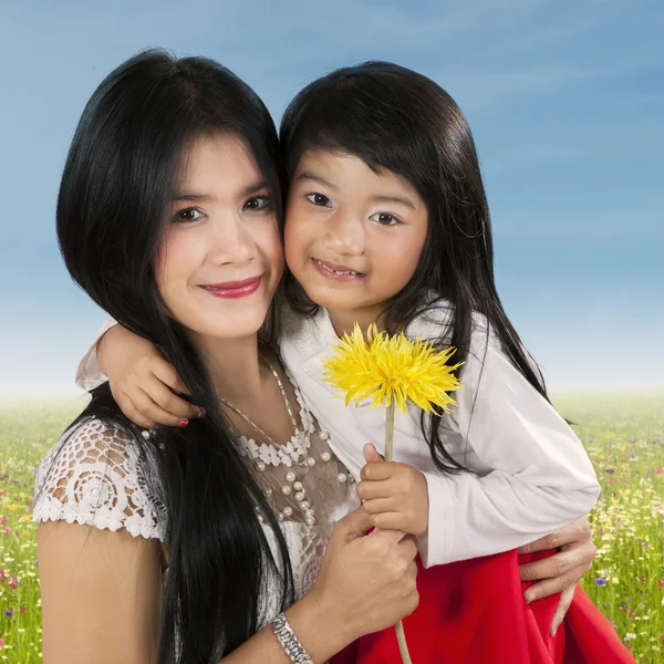 Mãe feliz segurando flor com seu filho — Fotografia de Stock