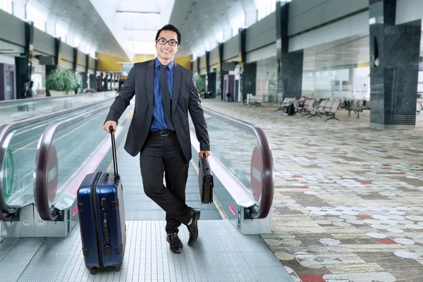 Empresário sorridente com bagagem na sala do aeroporto — Fotografia de Stock