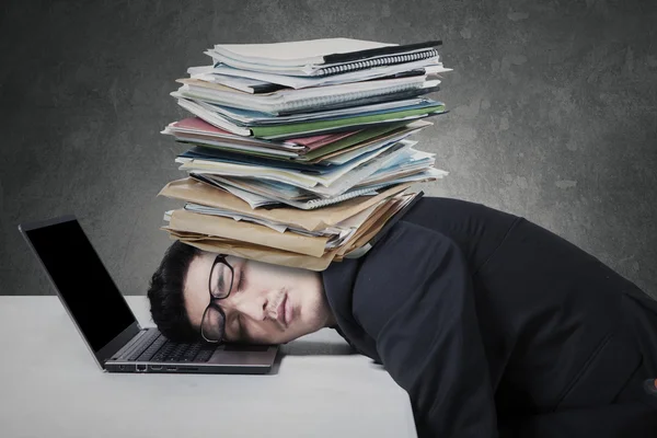 Exhausted man with paperwork on his head Royalty Free Stock Photos