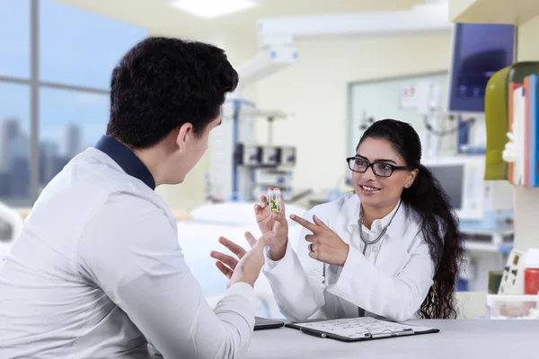 Dentista mulher explicando pílula para paciente — Fotografia de Stock