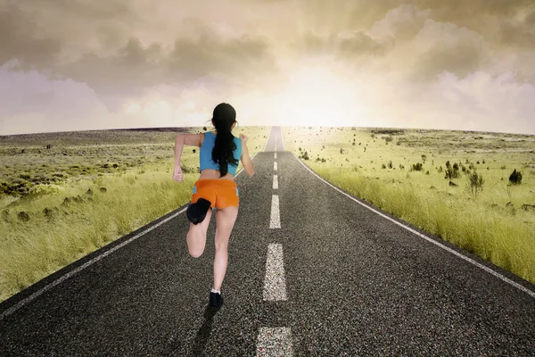 运行在道路的女子赛跑运动员 — 图库照片