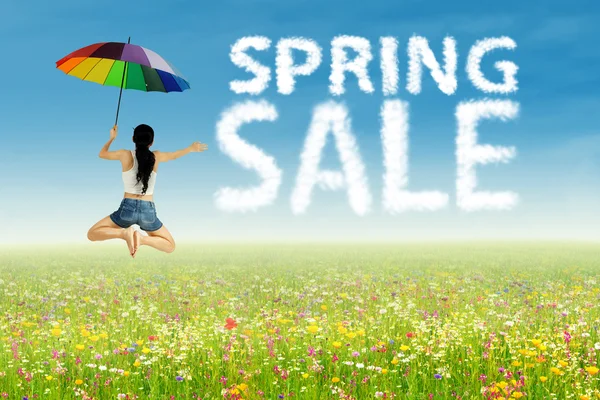 Girl jumping beside spring sale clouds — Stock Photo, Image