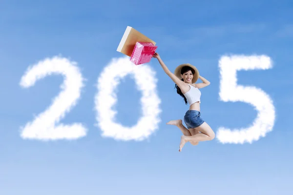 Girl with shopping bag jumping on the sky — Stock Photo, Image