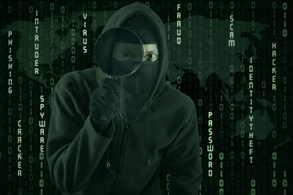Хакер використовує збільшувальне скло для шпигунства — стокове фото