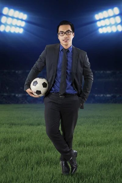 Мужской менеджер с футболом на поле — стоковое фото