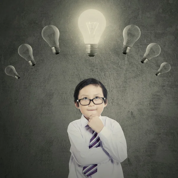 Schoolboy under bright lightbulb — Stock Photo, Image
