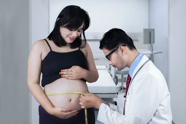 Médico midiendo a una mujer embarazada — Foto de Stock