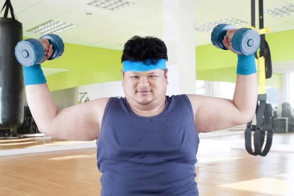 Fat man exercise in fitness center — Stock Photo, Image