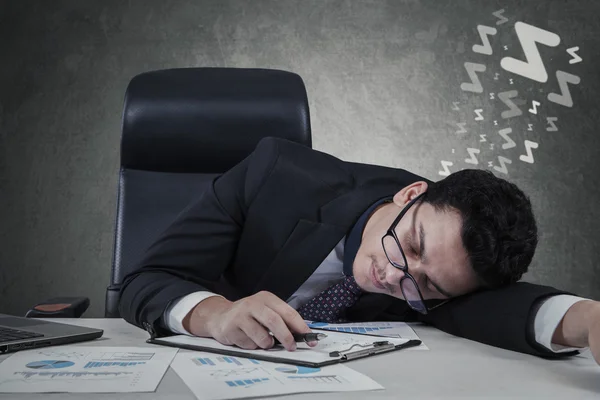 Affärsman liggande på skrivbordet med slutna ögon — Stockfoto