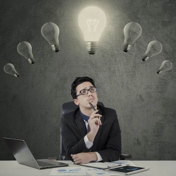 Creative worker looking at lamp — Stock Photo, Image