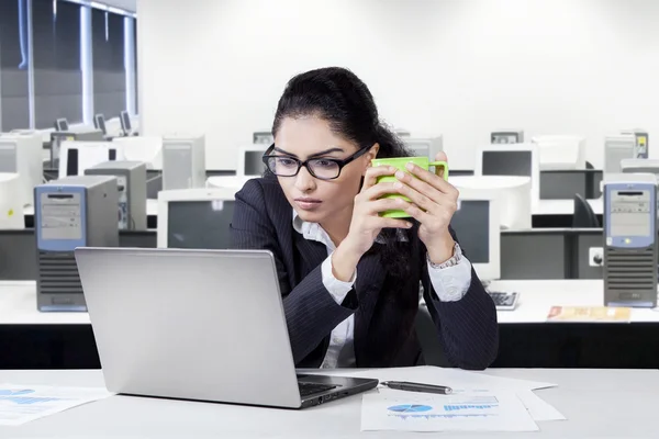 Kvinnlig chef med laptop hålla kaffe — Stockfoto