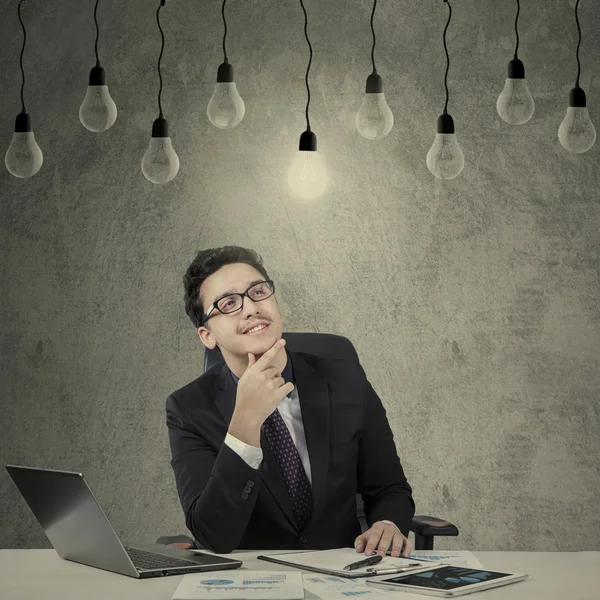Stilig entreprenör ser glödlampa — Stockfoto