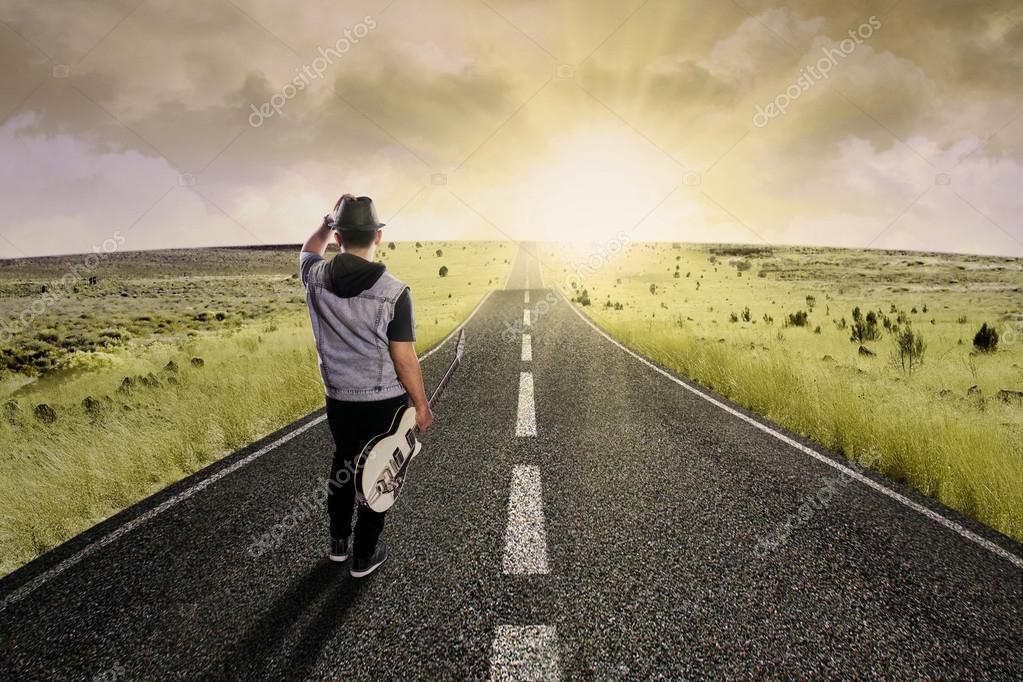 Lonely guitarist walking on road — Stock Photo © realinemedia