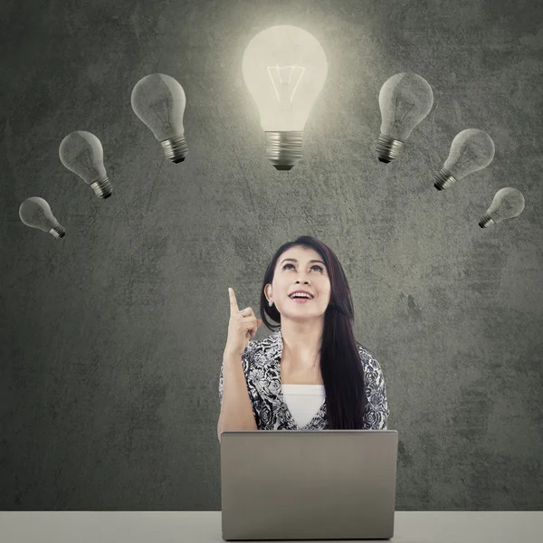 Woman with laptop under lightbulb — Stock Photo, Image
