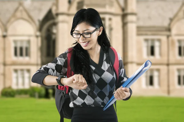 Attractive student looking at her watch — Stock Photo, Image