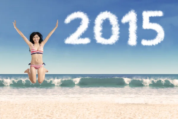 Mujer emocionada en la playa con números 2015 —  Fotos de Stock