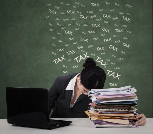 Confused female worker with tax documents — Stock Photo, Image