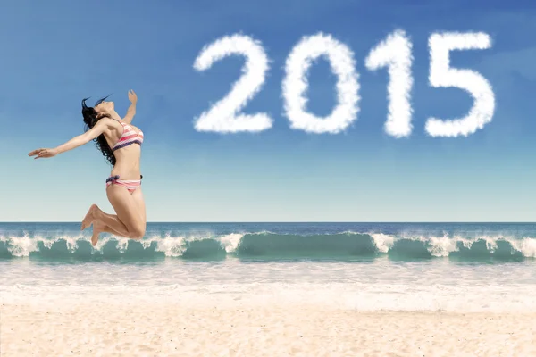 Glada kvinna i bikini med nummer 2015 — Stockfoto