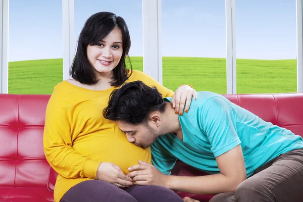 Orgulhoso marido beijando sua barriga esposa — Fotografia de Stock