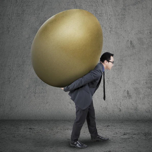 Successful manager carrying golden egg — Stock Photo, Image