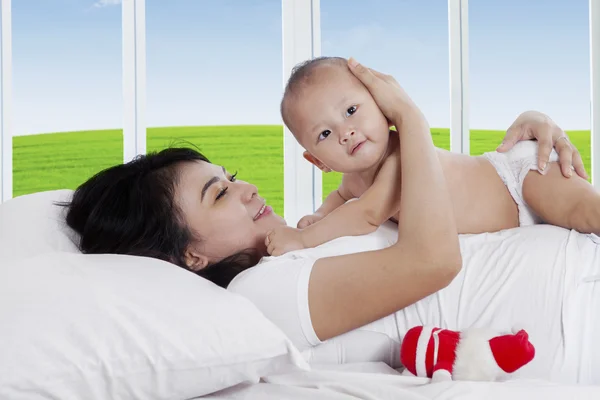 Asiática madre con bebé en el dormitorio —  Fotos de Stock